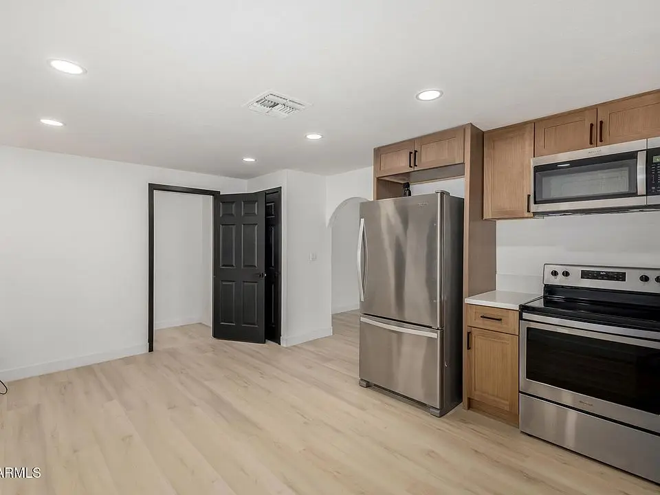 Finished interior at 1602 N 57th Ave with bright white walls, new flooring and kitchen