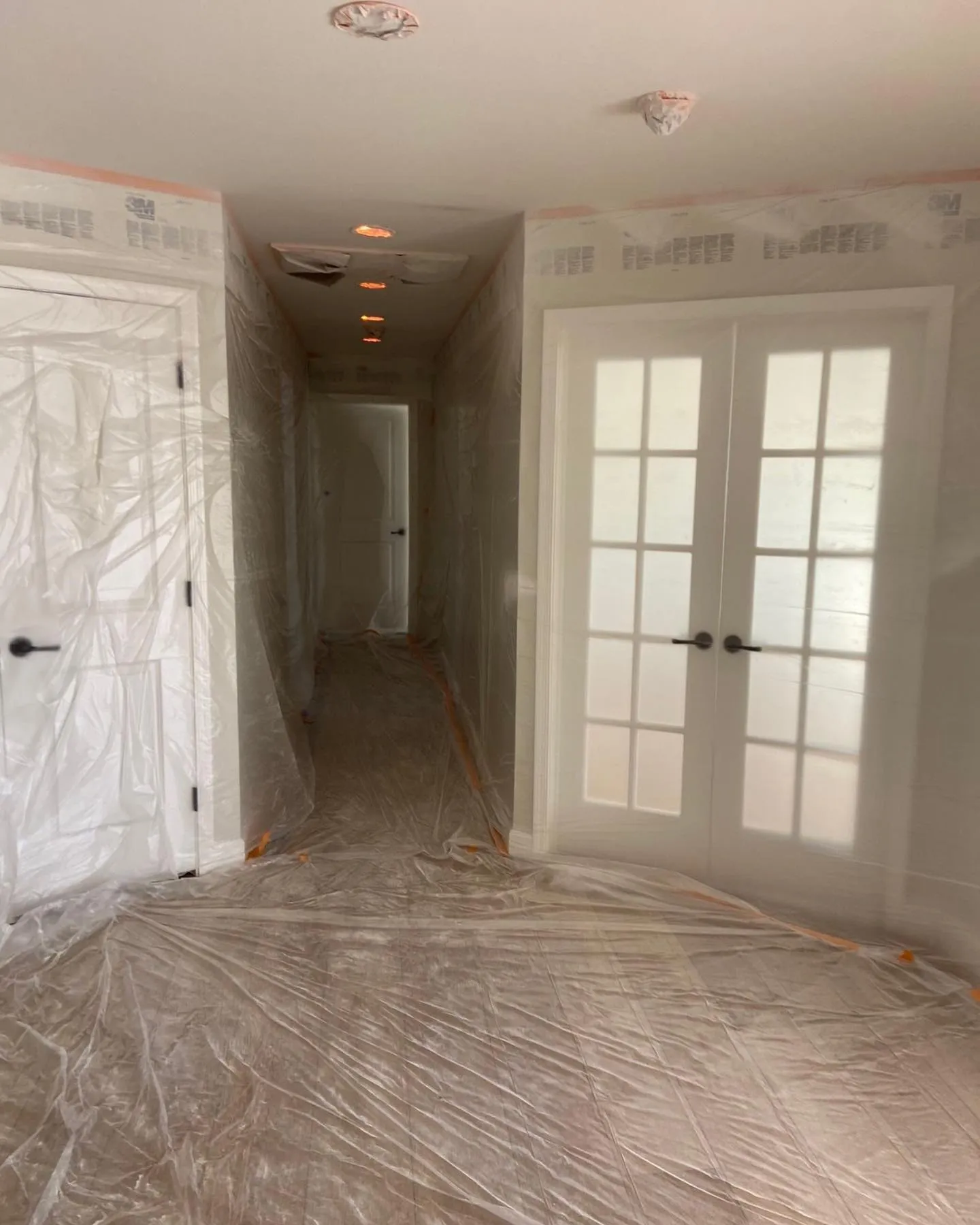 French doors and flooring protected with plastic and tape