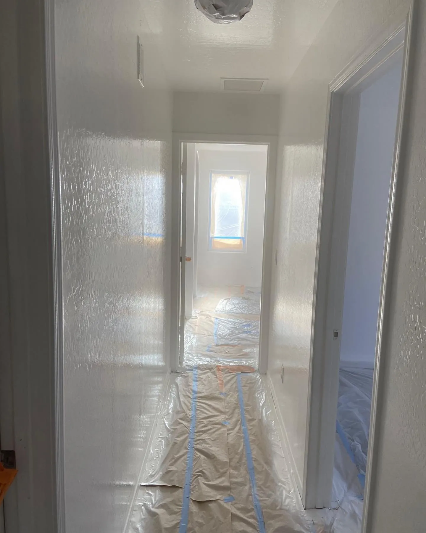 Hallway with floors fully masked before painting