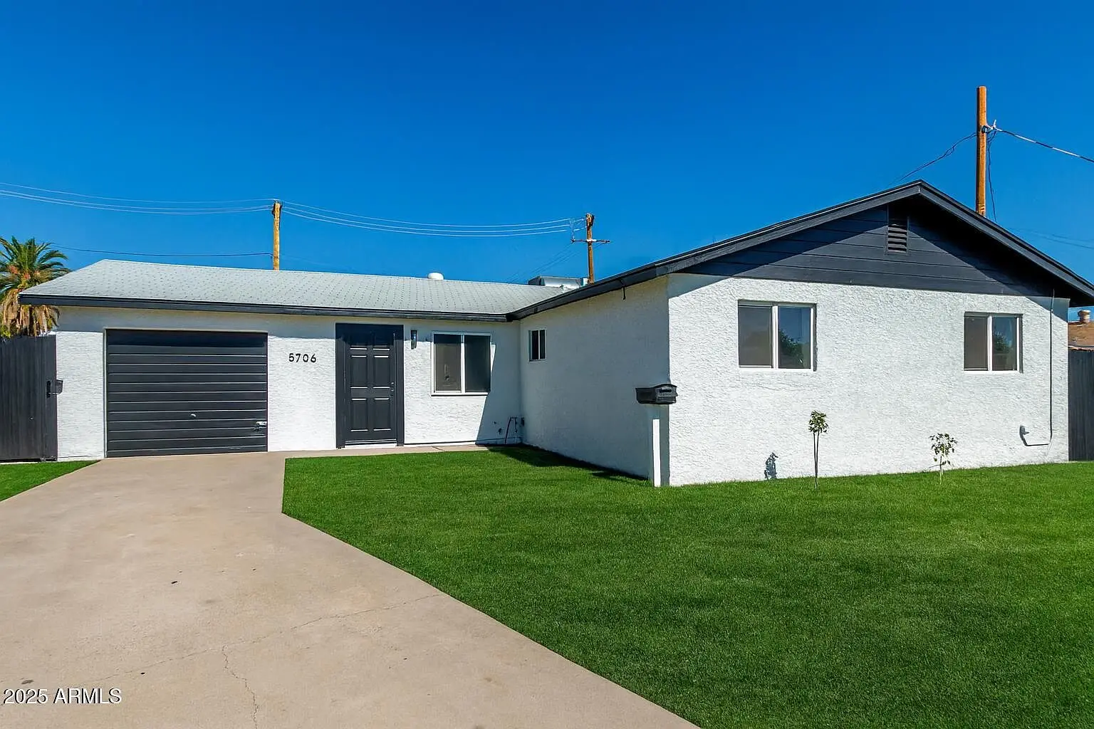 Two-tone white and charcoal exterior at 5706 W Sells Cir after the repaint